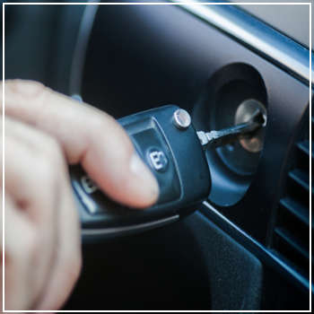 putting car key into the ignition 