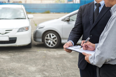 Insurance agent examining a damaged car