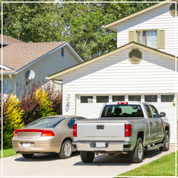 car and truck parked in front of garage 