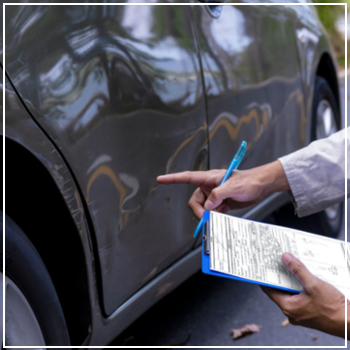 insurance adjuster examining car scratch