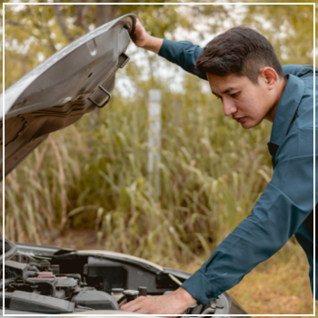 man checking under vehicle hood