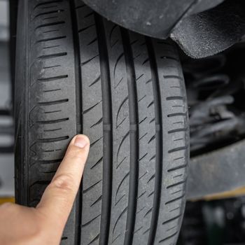 mechanic pointing at tire tread wear