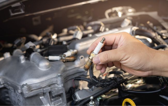 technician holding vehicle spark plug