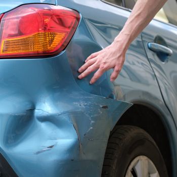 driver examining bumper damage