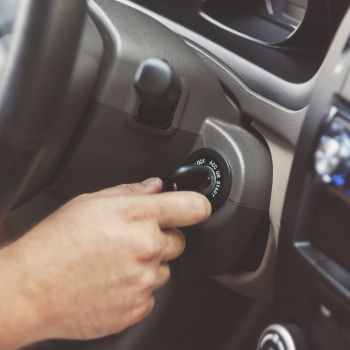 hand starting a car with the key